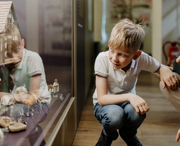 Junge betrachtet Vitrine (Anja Schalling)