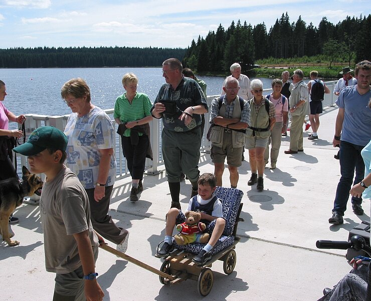 Wandergruppe beim Überqueren der Staumauer der Talsperre Carlsfeld ()