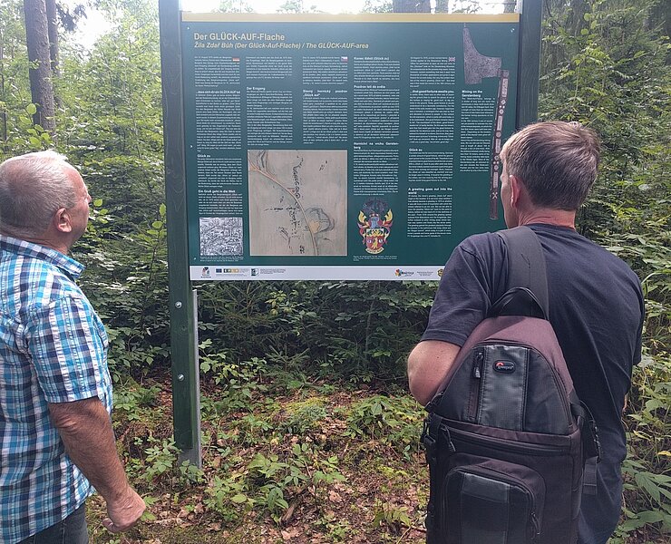 Besucher an Infotafel am Rundweg (Henry Pansch)